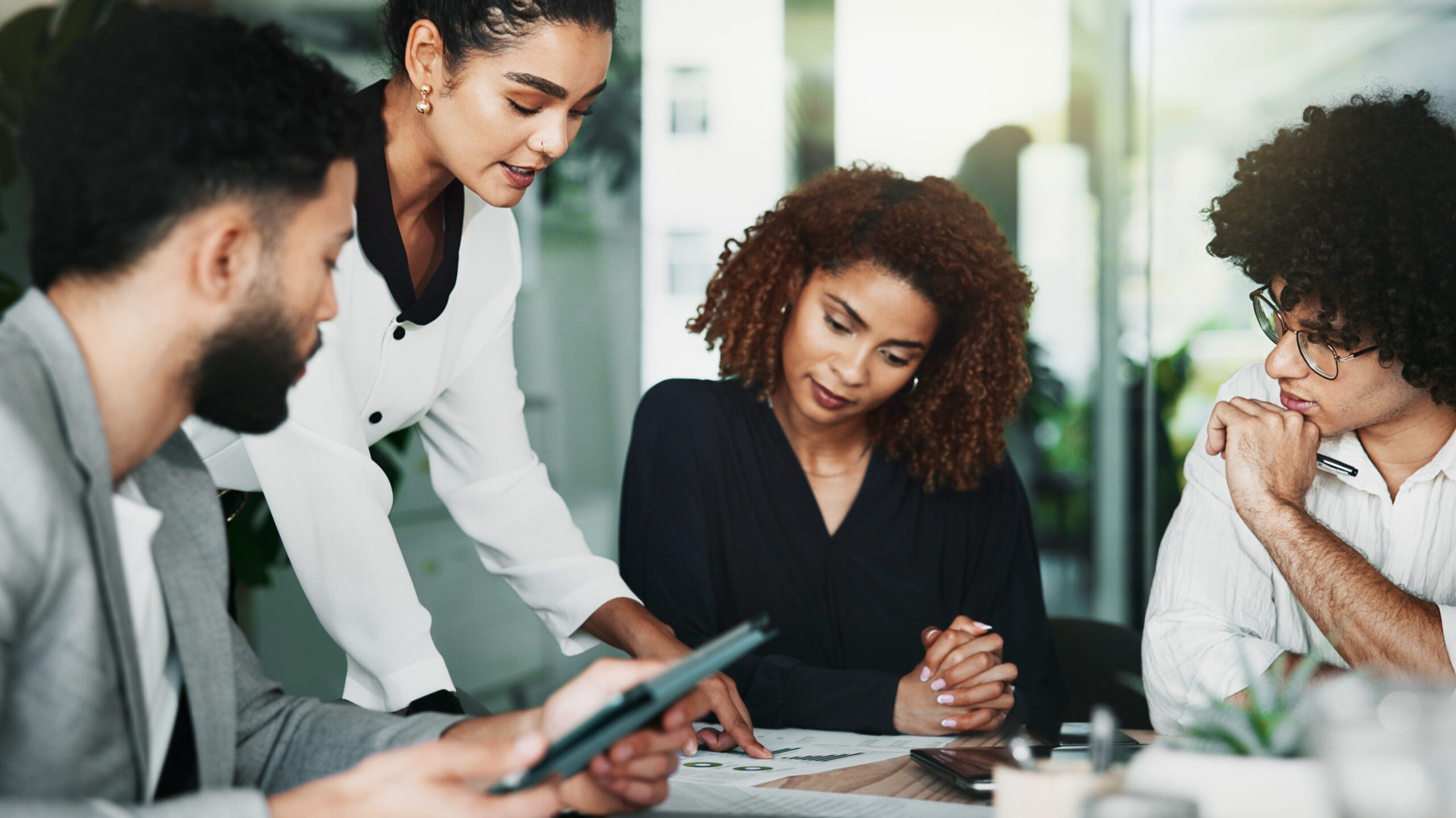 Vier collega's zijn met elkaar in gesprek. Iedereen luistert aandachtig.