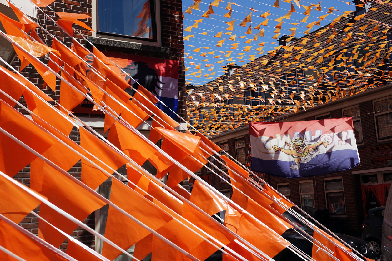Een straat vol oranje vlaggetjes.